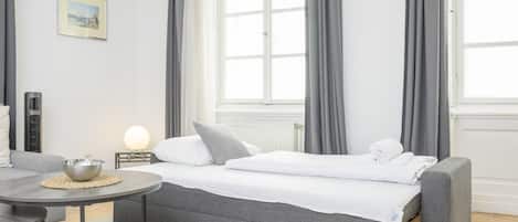 Une chambre d’hôtel avec un lit, une table ronde, un bol et un tableau accroché au mur.