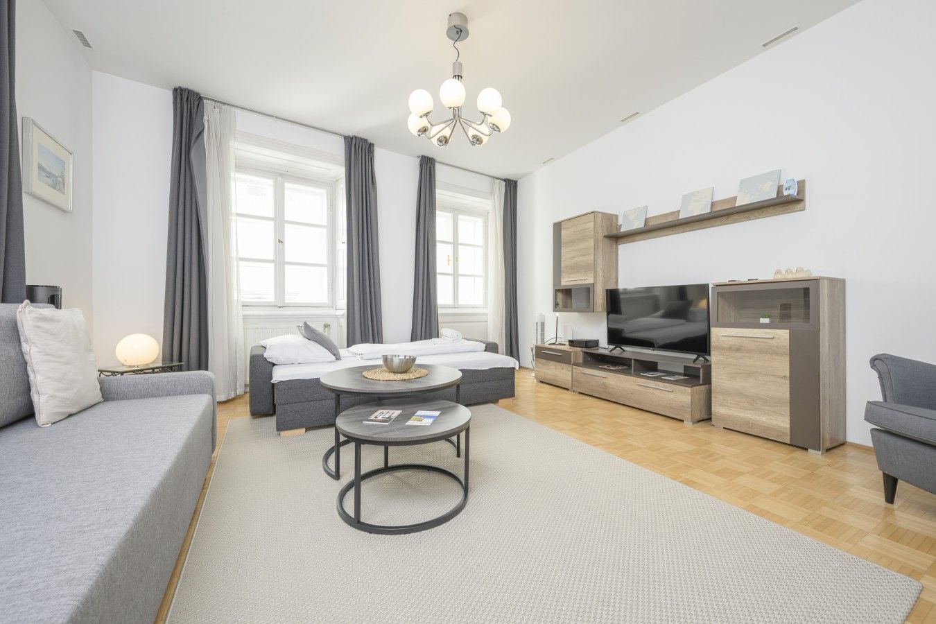 Ein modernes Wohnzimmer mit einer Couch, einem Couchtisch, einem Fernseher und einem Kühlschrank.