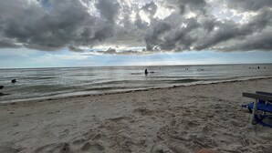 Ein Strand mit sandigem Ufer und bewölktem Himmel.