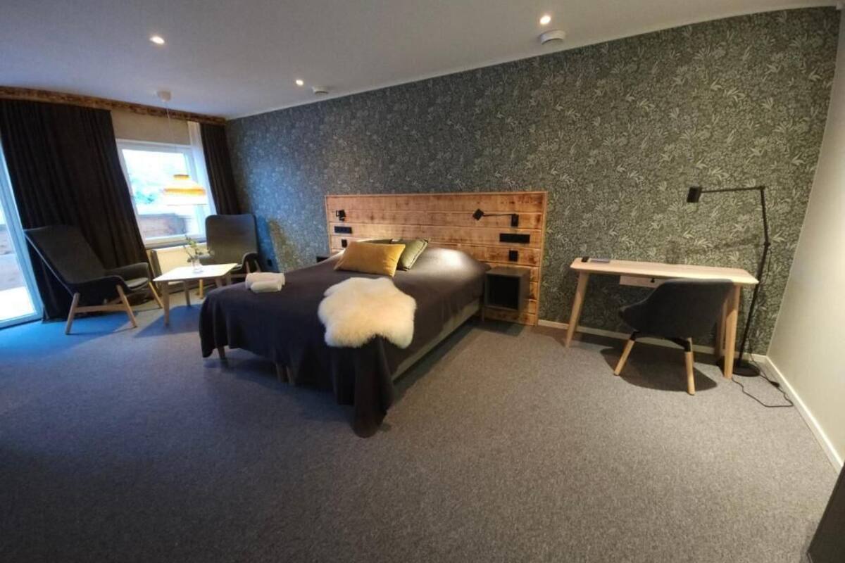 Quarto de hotel moderno com uma cama grande, uma escrivaninha e uma cadeira.