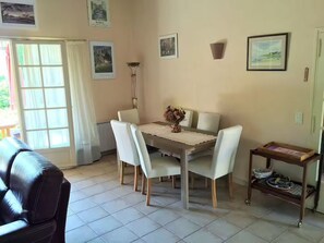 A dining area with a table and chairs, a lamp, and a small table with a tray. - sur la Colline Tranquille une Confortable Villa Provencale Pour 8 Personnes (83150 - BANDOL)