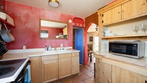 A kitchen with wooden cabinets, a double sink, and a microwave.