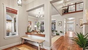 A spacious hallway with a wooden bench, a rug, and a staircase leading to an upper level. - Large Modern 5 Bedroom Custom Home (Meridian)