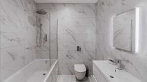 A modern bathroom with a bathtub, toilet, and shower area, featuring marble tiles and a large mirror. - Modern 2 Bed Ground Floor - Parking - By Tempstay (Berkshire)