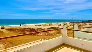 Un balcón con vista a la playa y al océano.