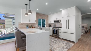 A modern kitchen with white cabinetry, a central island, and a built-in oven.