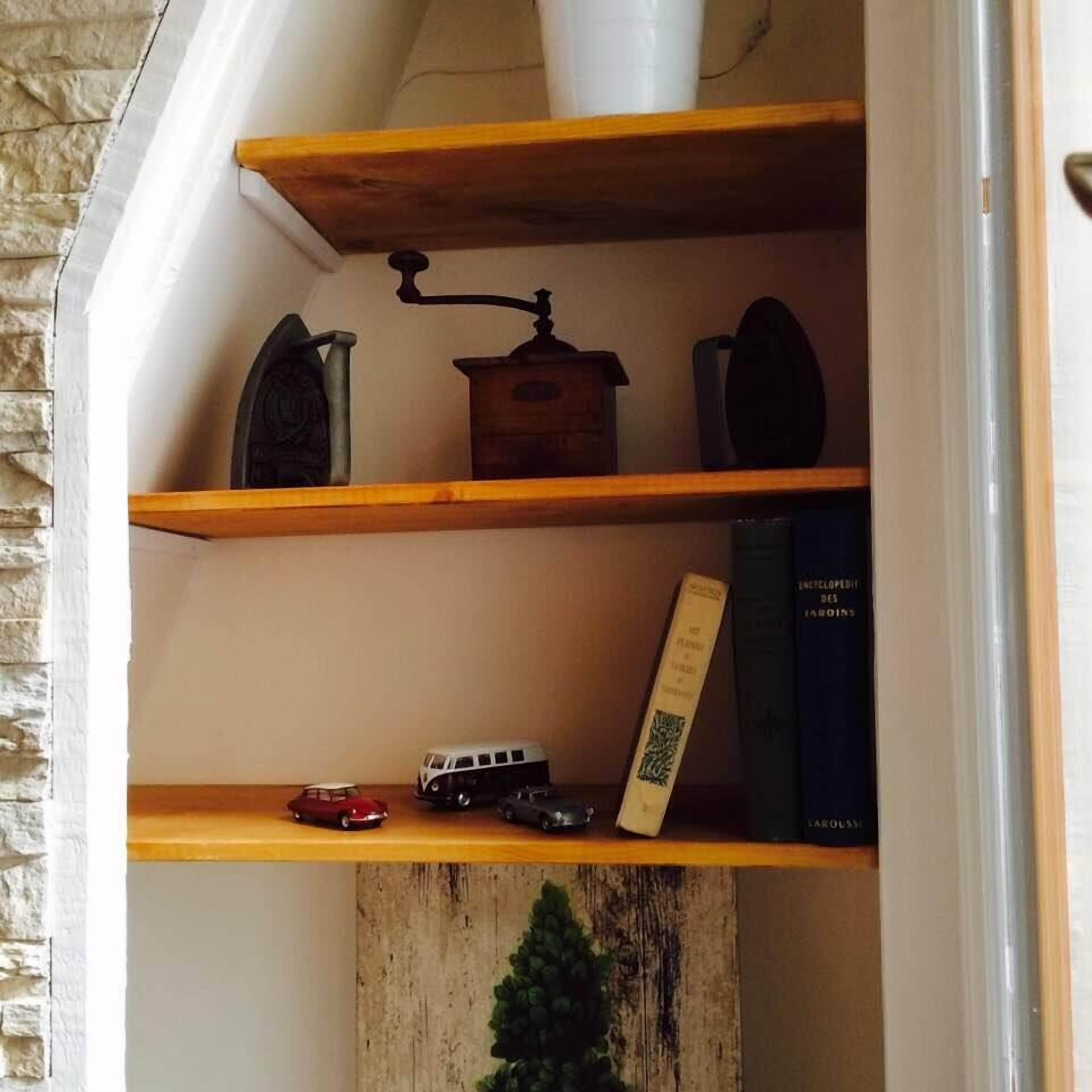 A shelf with a vintage scale, a small car, and a book titled 'Encyclopédie des Jardins'.