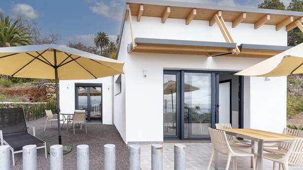 A modern outdoor patio with a dining table, chairs, and umbrellas. - SOL UNA Joya (CN)