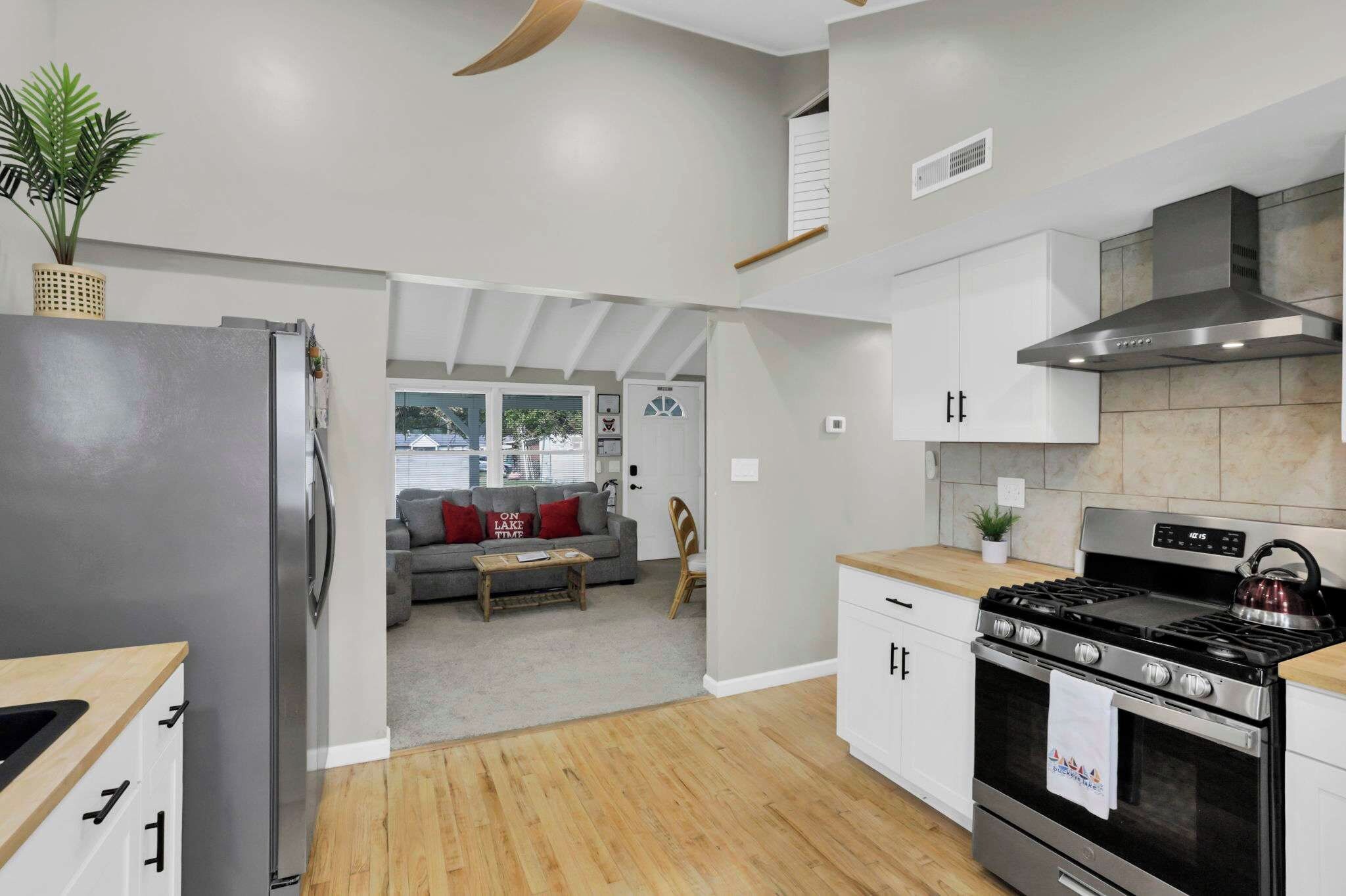 Una cucina moderna con piano cottura integrato, forno e mobili bianchi.