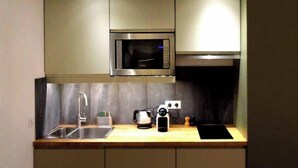 A compact kitchen with a microwave, sink, and cabinets. - Nest Bailly. Superbe Studio Pigalle/montmartre (Paris)