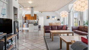 Un salon moderne avec une cheminée, des canapés, une table basse et un téléviseur.