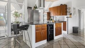 Une cuisine moderne avec des meubles en bois, des appareils en acier inoxydable et un grand îlot central.