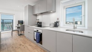 A modern kitchen with a large window, a built-in oven, and a view of the city. - Skyvillion 2 Bed Apt London Excel  O2 Arena (London)