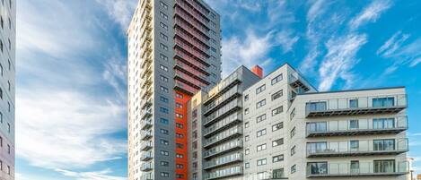 Un moderno edificio de gran altura con múltiples balcones y techo plano.