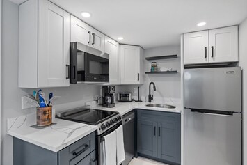 Kitchen with coffee maker, toaster, and all standard appliances, including dishwasher.