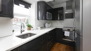 A modern kitchen with a stainless steel refrigerator, a microwave, and a built-in oven. - Skyvillion - Central Ldn 3bed Flat Ladbroke Grove (London)