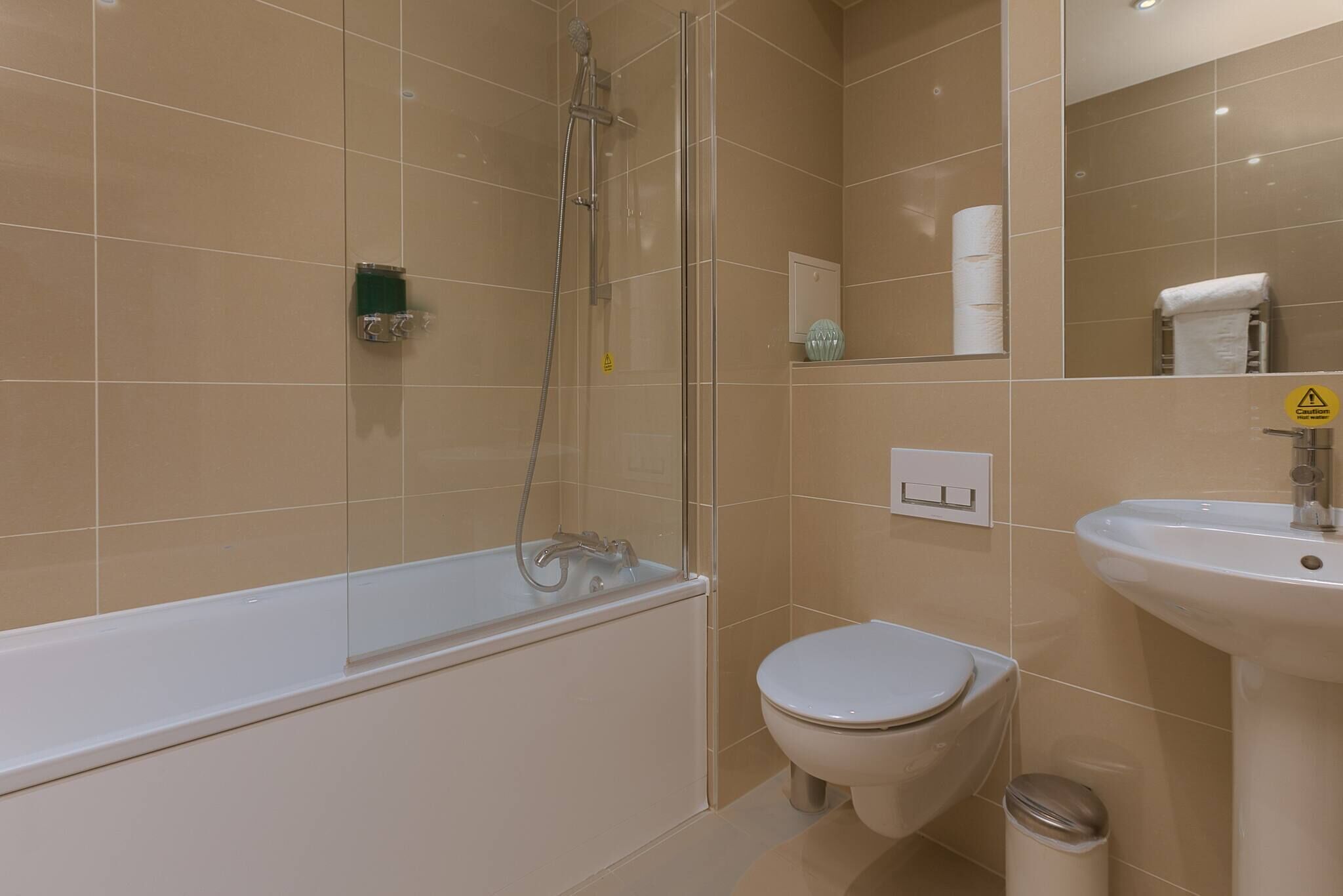 A bathroom with a bathtub, toilet, sink, and a glass-enclosed shower.
