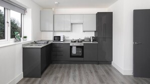 Una cucina moderna con forno integrato, microonde e lavello.