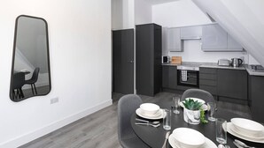 Una cocina moderna con armarios oscuros, microondas y tostadora.