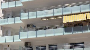 A multi-story building with balconies, air conditioning units, and a yellow-striped awning on one of the upper floors. - Apartment in Blanes with pool, near the beach (Blanes)
