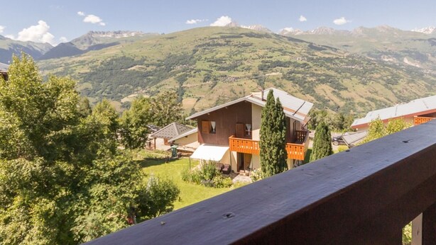 Bergblick mit einem Holzhaus und einem Balkon.