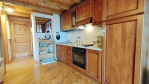 Une cuisine avec des armoires en bois, un plan de travail et un four encastré.