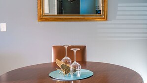 Una mesa de comedor con un espejo encima, una araña y un insecto decorativo sobre un mantel individual.