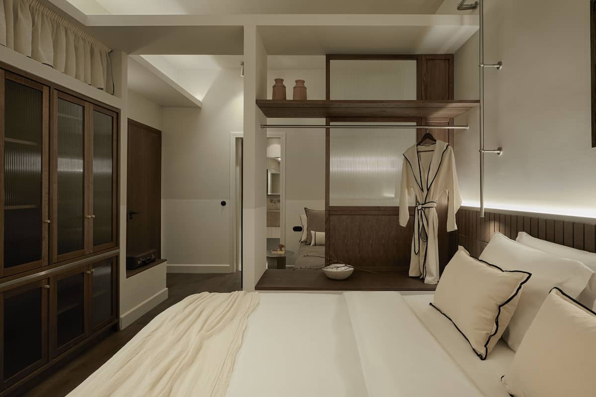 Un dormitorio con una cama grande, un armario, un vestidor y un baño con toallero.