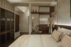 Quarto com cama grande, guarda-roupa, closet espaçoso e banheiro com porta-toalhas.