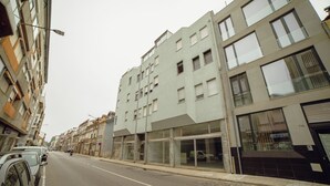 A multi-story building with a modern architectural design, featuring large windows and a flat facade. - Alegria Flat City Center by Vacationy (Porto)