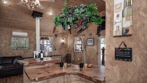 A rustic bar area with wooden furniture, a hanging plant, and a chalkboard with a message. - Sandoval in the Historic Upper Canyon (Ruidoso)