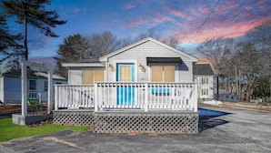 A two-story house with a white exterior, a blue door, and a balcony with a white railing. - Gull's Nest by Bayley Vacation Rentals (Old Orchard Beach)