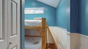 A room with a bunk bed, a window with a view, and a door.