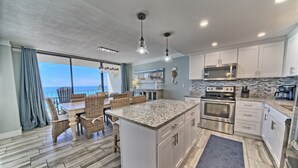 A modern kitchen with white cabinets, stainless steel appliances, and a large island. - Tower 2-1002 Edgewater Beach Resort-Sleeps 8! (Panama City Beach)