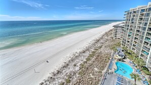 A beachfront hotel with a swimming pool, beach access, and a pier in the background. - Tower 2-1002 Edgewater Beach Resort-Sleeps 8! (Panama City Beach)