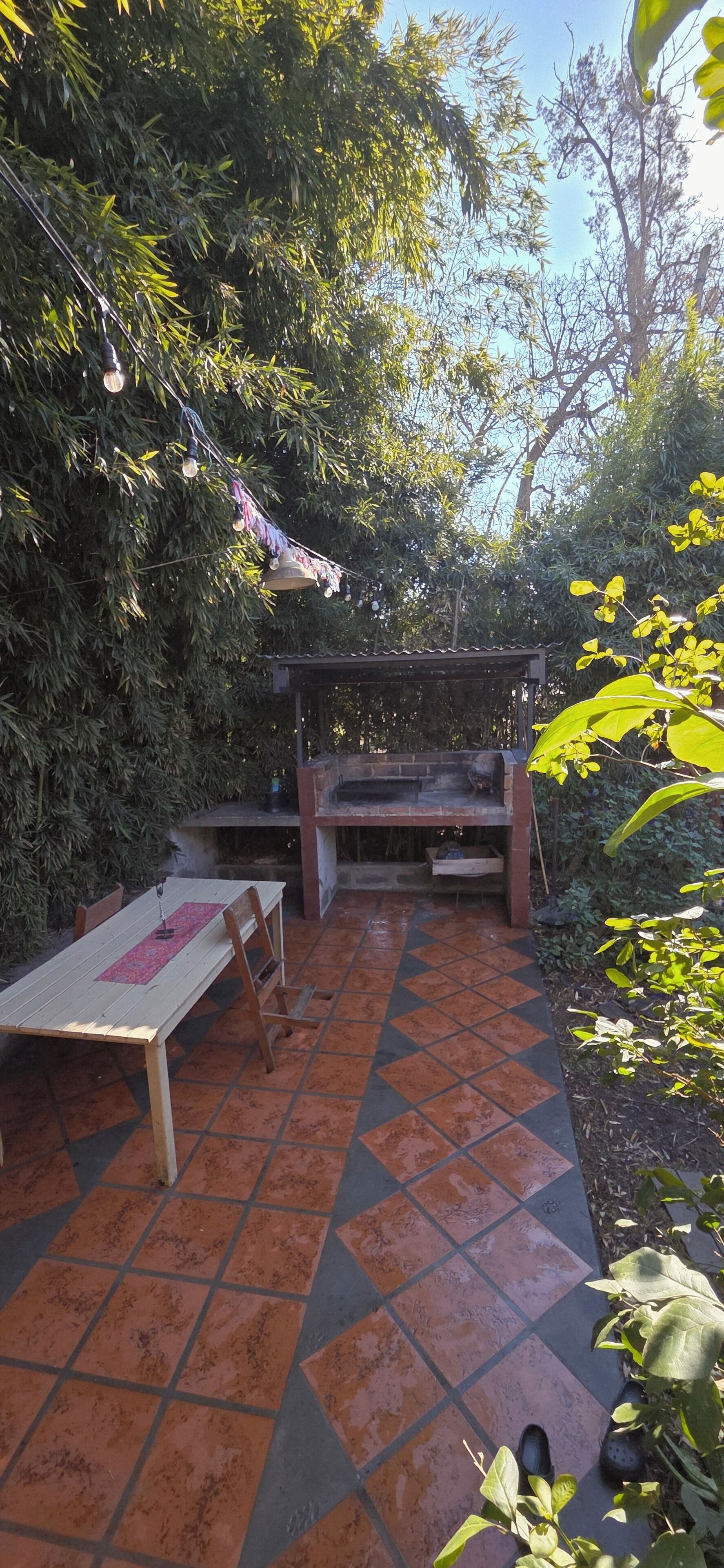 Un patio al aire libre con una parrilla, una mesa y sillas.