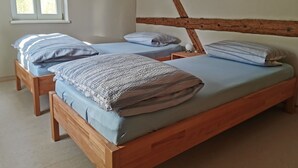A bedroom with two wooden beds, a window, and a wooden headboard. - Im Herzen der Sächsischen Schweiz- Fewo Bloßstock für Max. 5 Personen (Sebnitz)