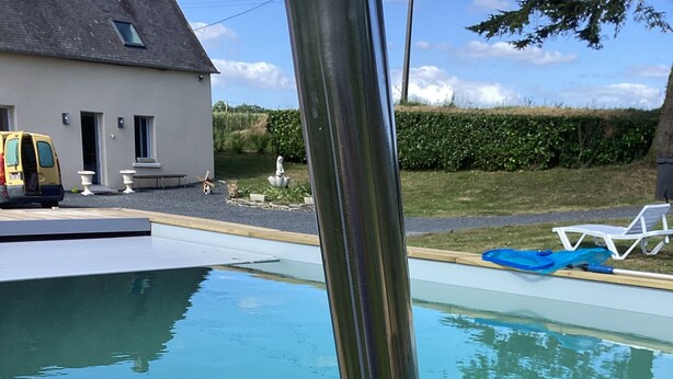 Una piscina con cubierta de madera y barandillas metálicas.