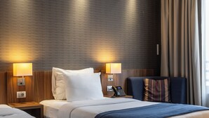 A hotel room with two beds, a wooden headboard, a telephone, and a nightstand with a lamp. - Nobel Palace Hotel (Belgrade)