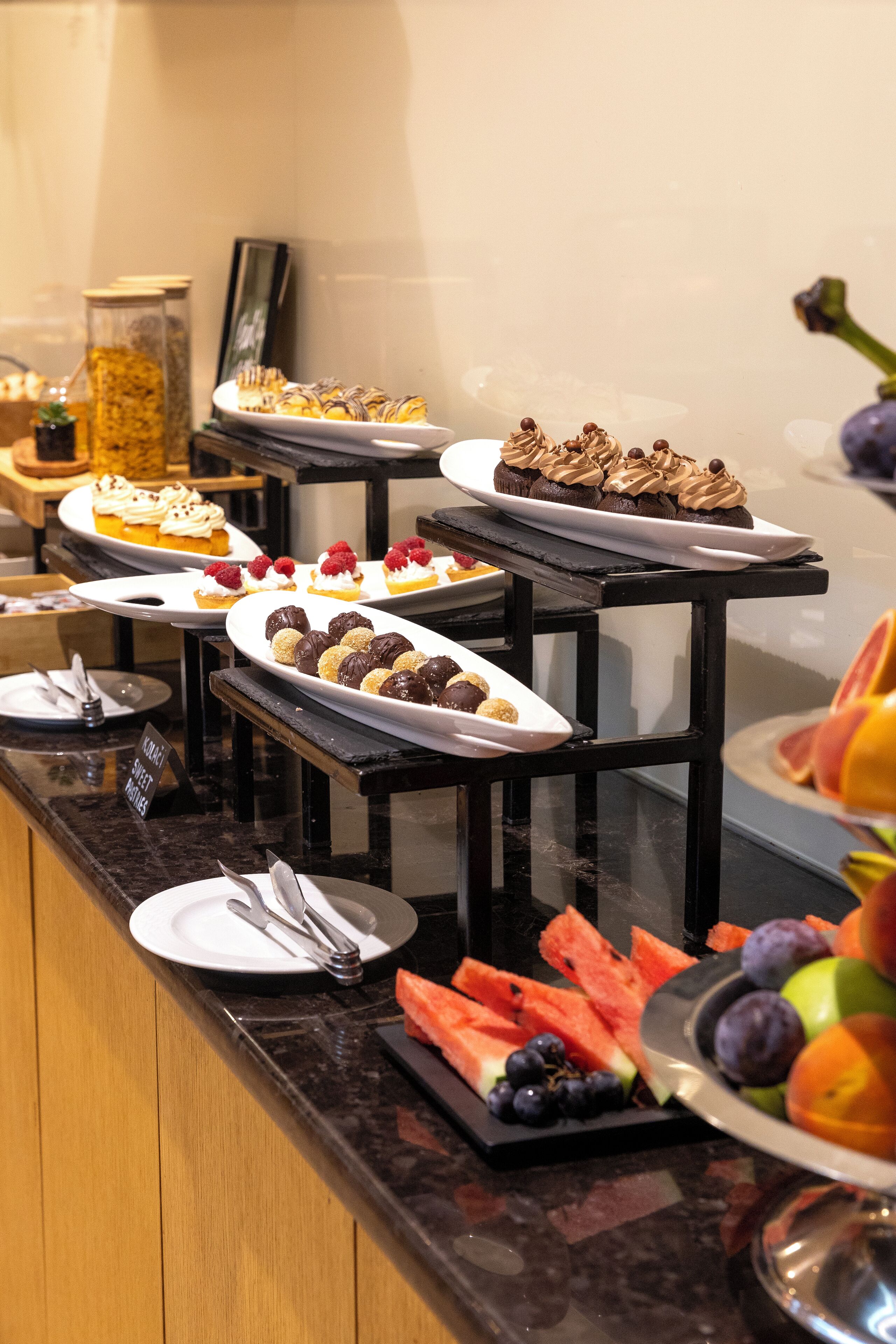Un bufé con diversos postres y frutas.