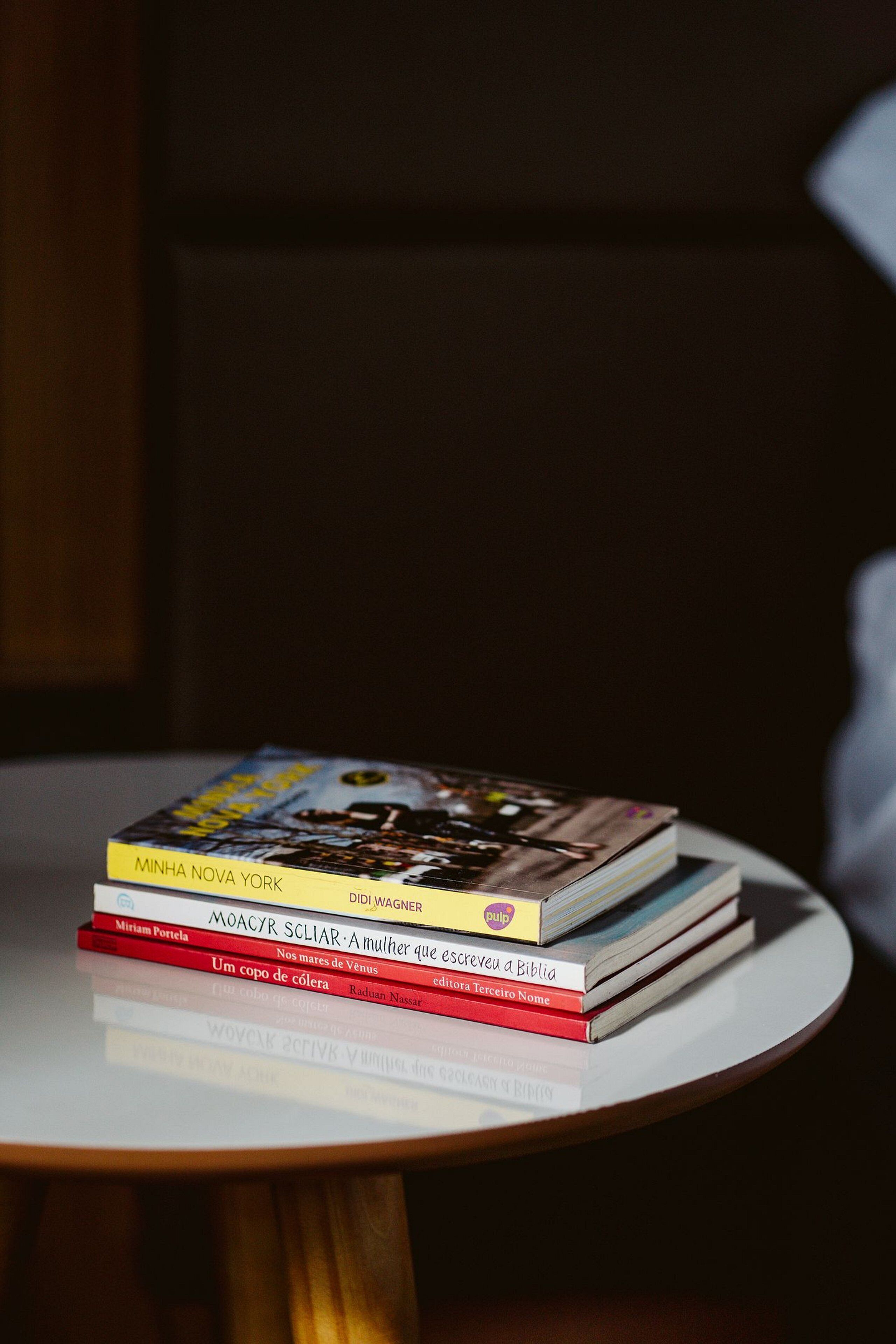 A stack of books on a round table.