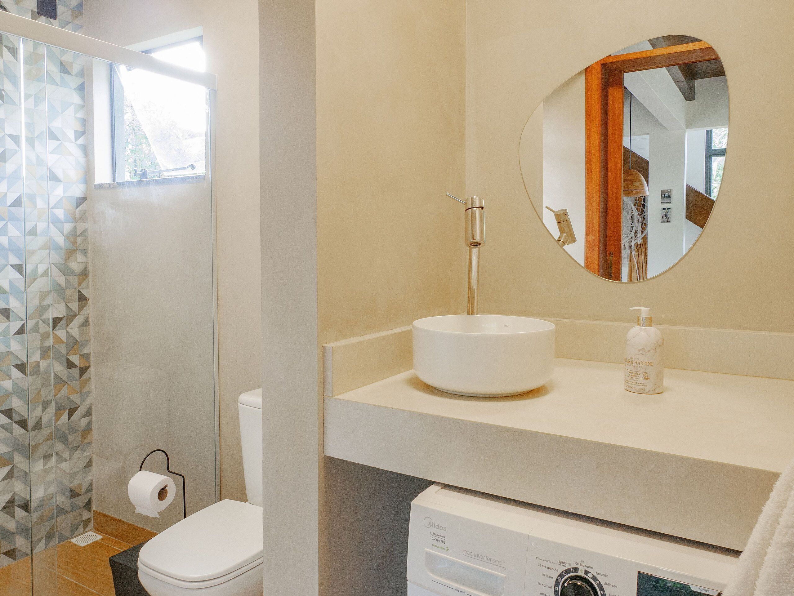 A bathroom with a white sink, a mirror, and a toilet.