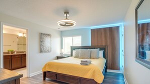 Een slaapkamer met een houten bed, een nachtkastje en een bedtafel.