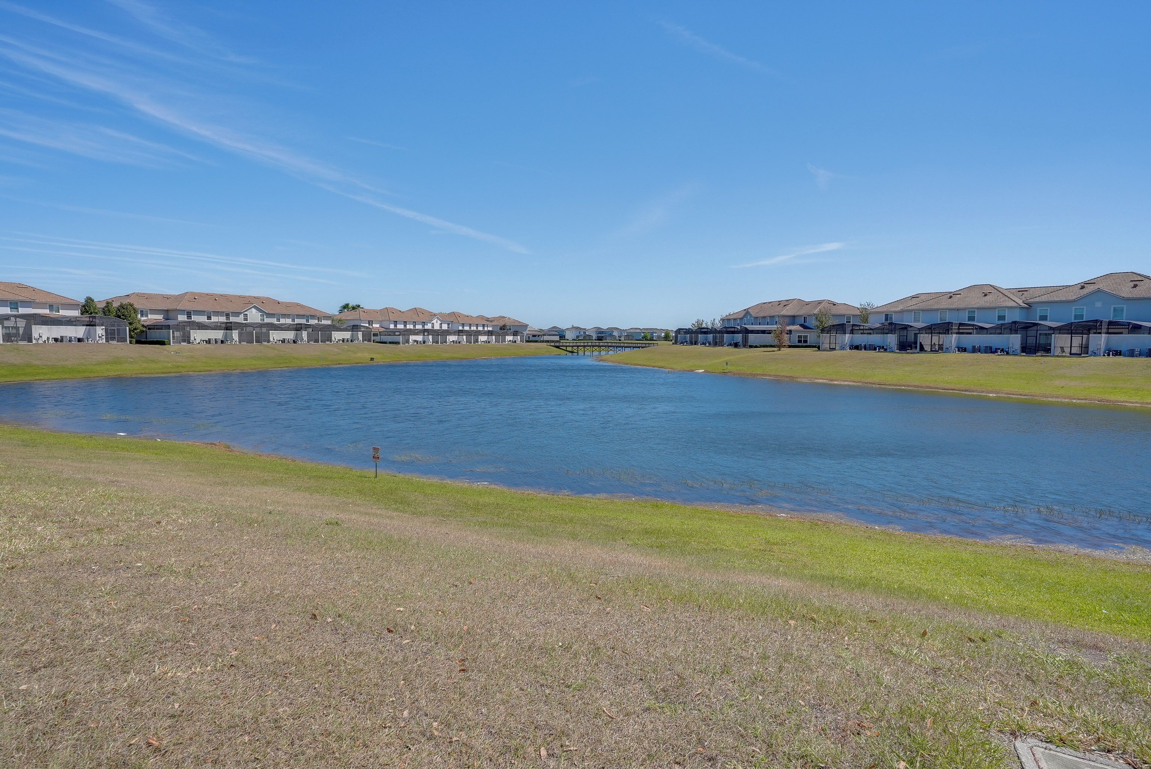 A residential area with a lake, houses, and a dock.