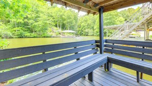 A wooden deck with a bench overlooking a body of water, surrounded by lush greenery. - 'gabbi's Getaway' - Little Tallapoosa River Cabin (Wedowee)