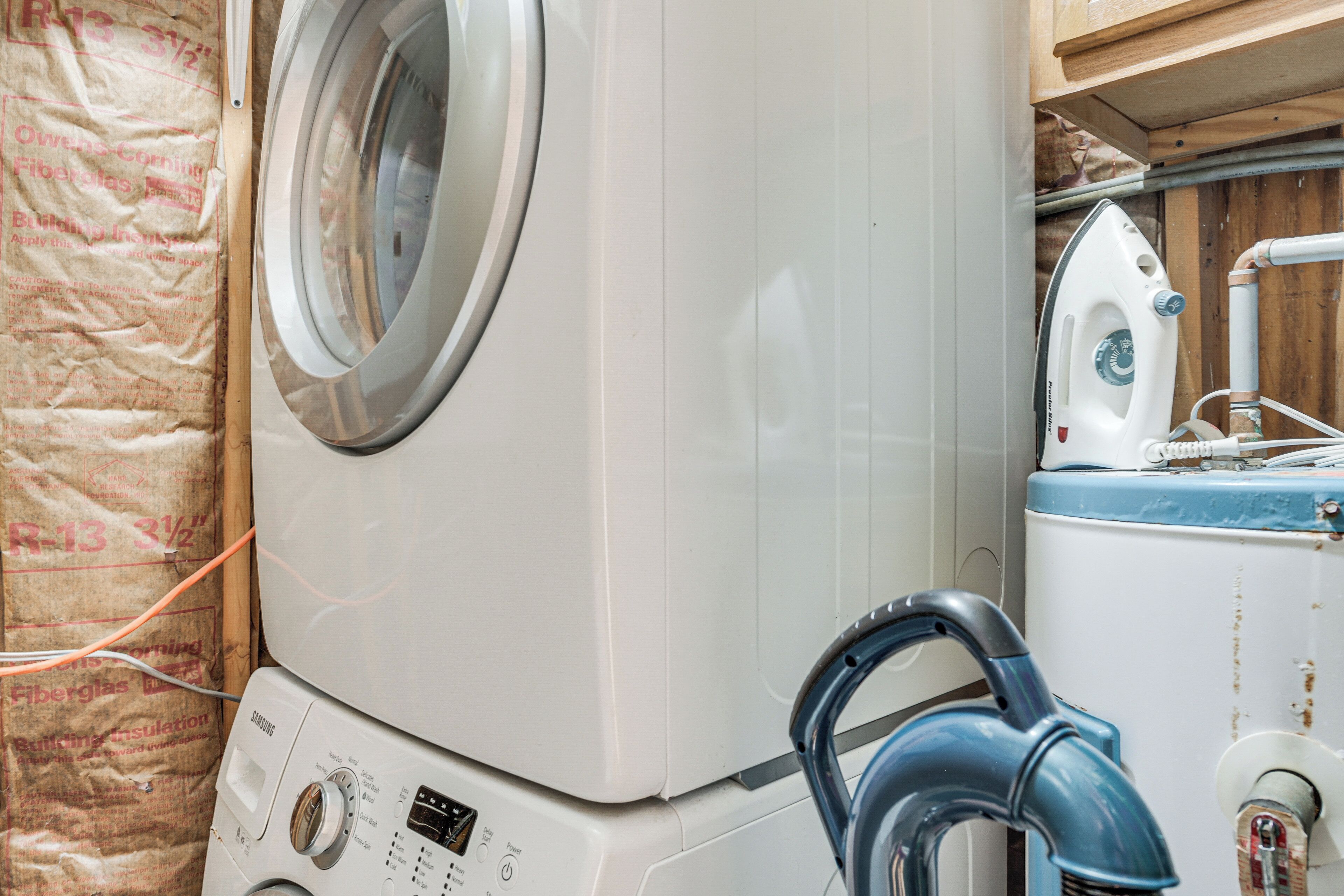 A laundry area with a front-loading washing machine, an iron, and a water heater.