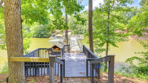 A wooden deck leading to a dock over a lake, surrounded by trees. - 'gabbi's Getaway' - Little Tallapoosa River Cabin (Wedowee)
