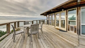A wooden deck with a table and chairs, overlooking a body of water. - Serene Irish Beach Home w/ Panoramic Ocean Views! (Manchester)
