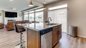 A spacious kitchen with a central island, built-in dishwasher, and a large window providing natural light. - 17 Mi to Dtwn Denver: Modern Aurora Home w/ Yard (Aurora)