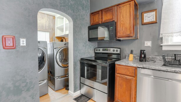 A compact kitchen with stainless steel appliances, wooden cabinets, and a built-in oven. - Niles Vacation Rental Near St Joseph River! (Niles)